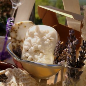White lavender soap surrounded by ingredients in sunlight