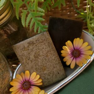 2 organic peppermint nettle soaps showing both their front aand back surrounded by flowers in a miniature bathtub