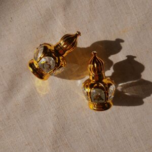 Two scented oil perfume bottles laid down on a beige canvas