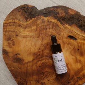 Cinnamon leaf essential oil in amber dropper bottle on a wooden board